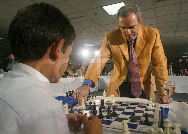 foto do sr Kasparov movimentando uma peça no jogo contra Samuel Edelstein